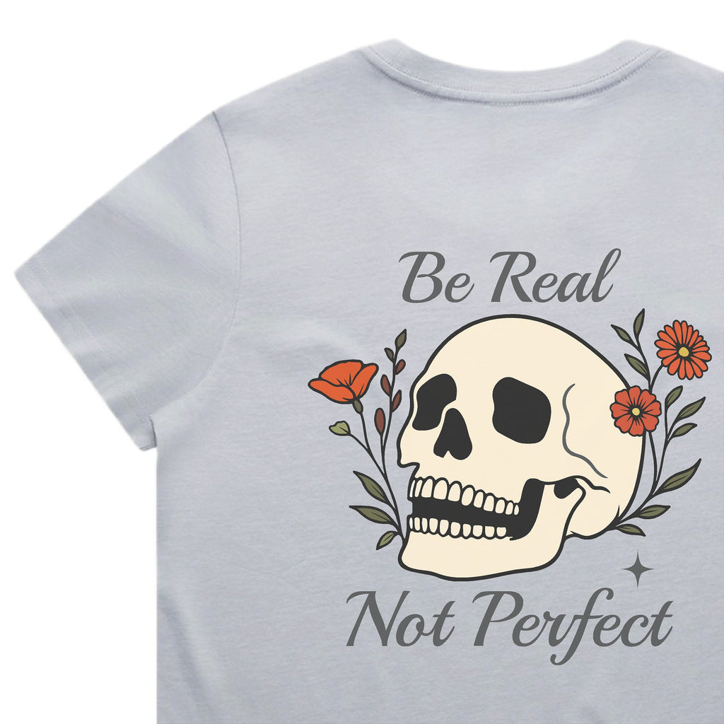 Light blue t-shirt with a skull design and text 'Be Real Not Perfect' on a white background