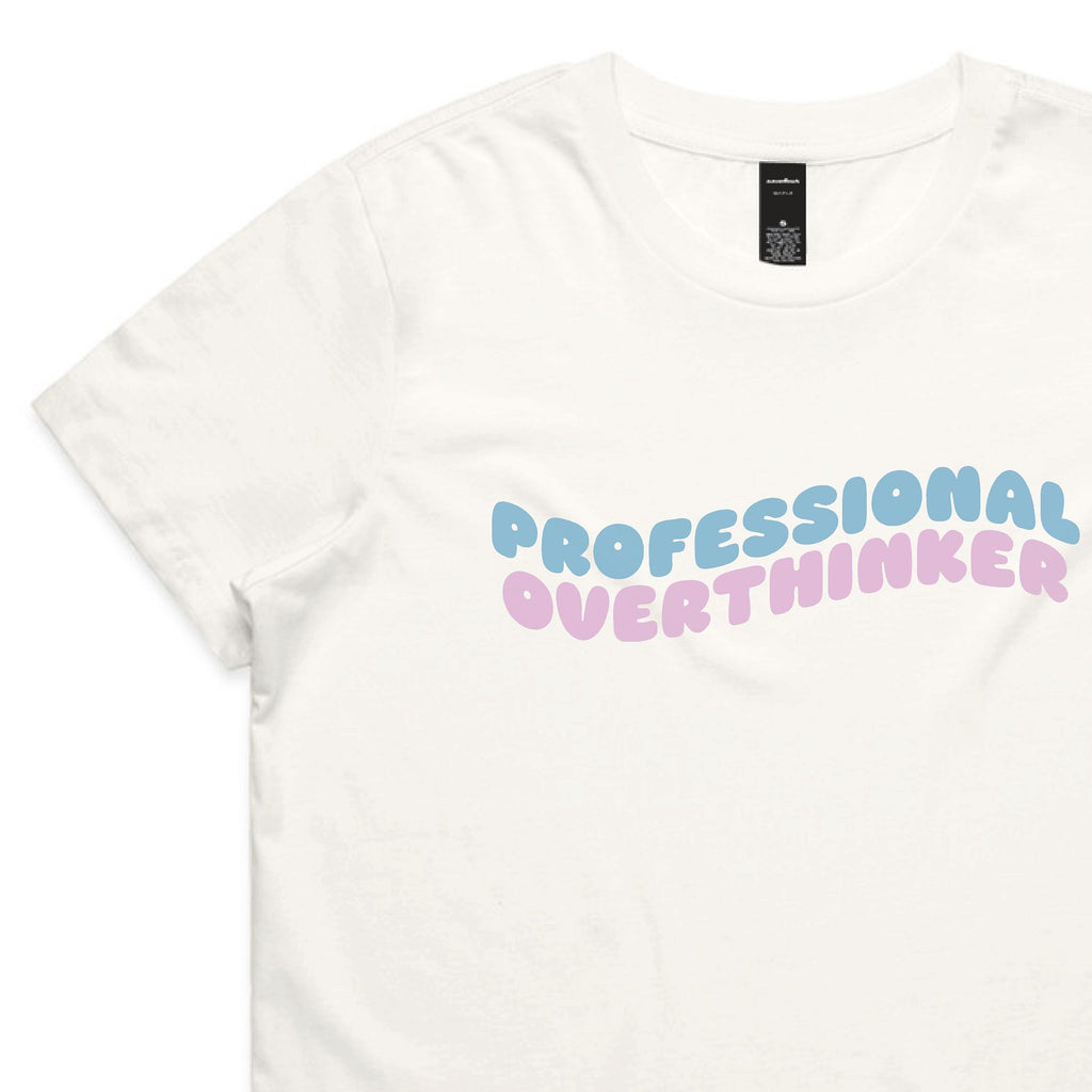 White t-shirt with 'PROFESSIONAL OVERTHINKER' text in pastel colors on a white background